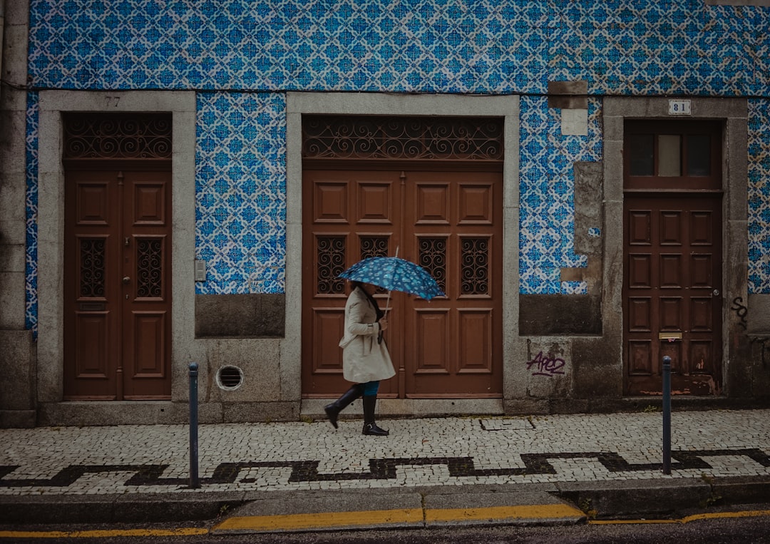 person in gray coat walking on sidewalk during daytime