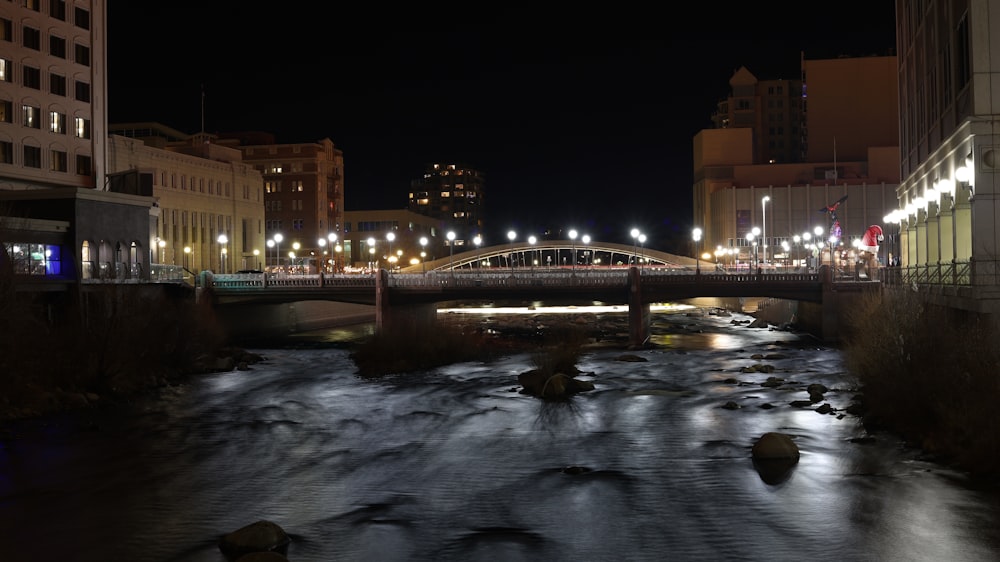 body of water near lighted building during night time