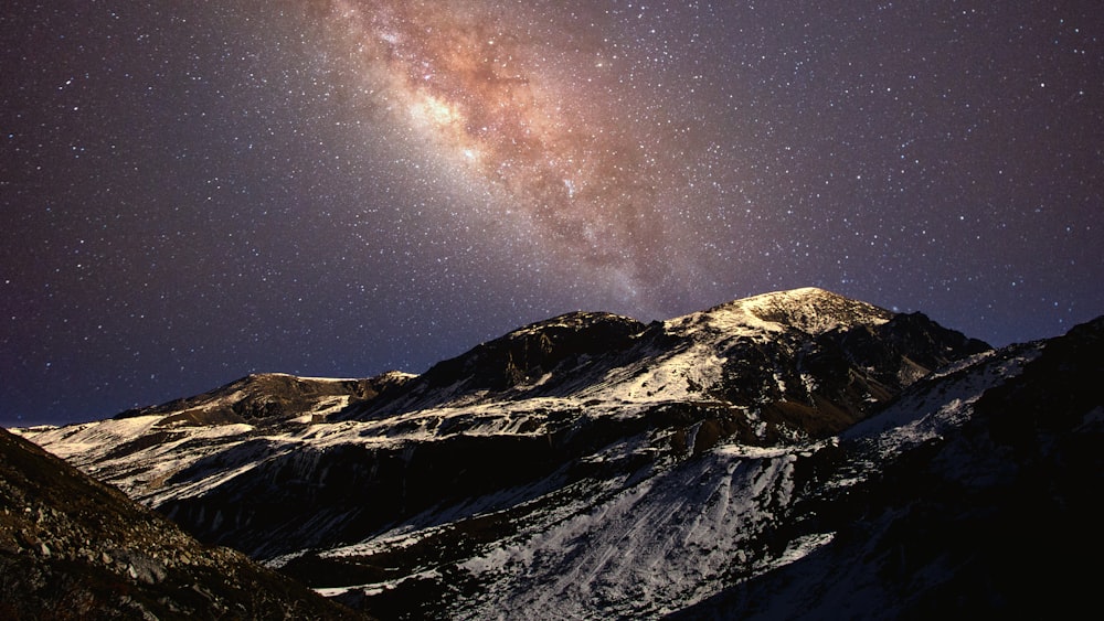 snow covered mountain under starry night