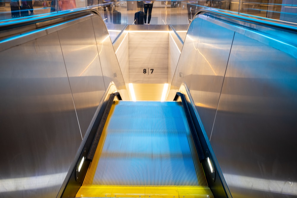 blue and yellow escalator in a train station