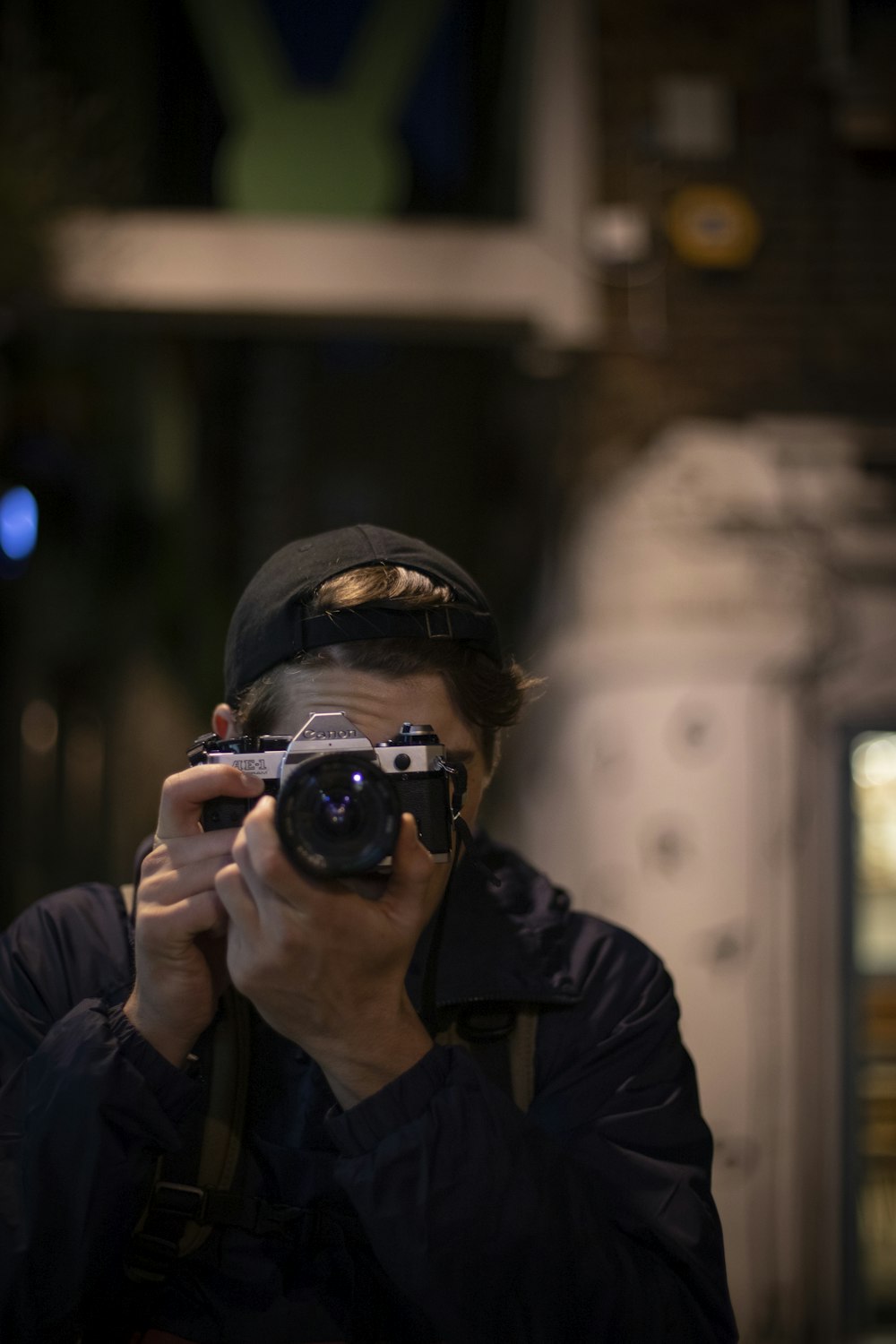 man in black jacket holding black camera