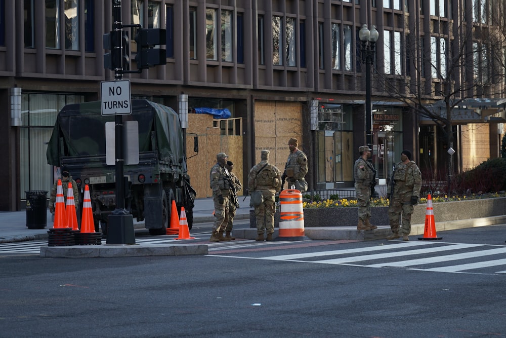 man in green and brown camouflage uniform standing on pedestrian lane during daytime