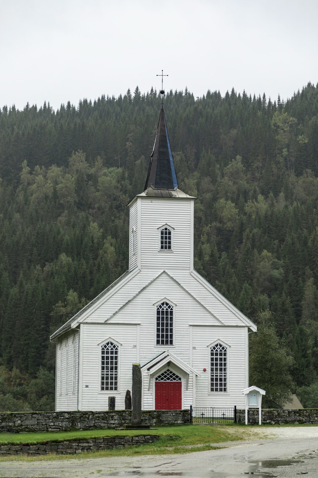 white and green church surrounded by green trees during daytime