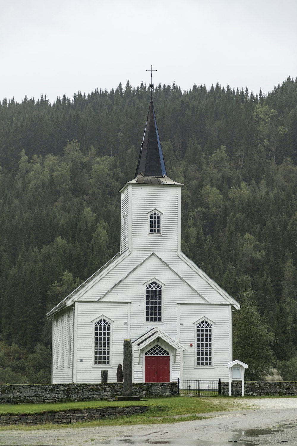 white and green church surrounded by green trees during daytime