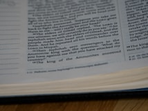 A close-up view of an open book showing printed text with some underlined words. The text appears to be a passage, possibly from a religious or spiritual book.