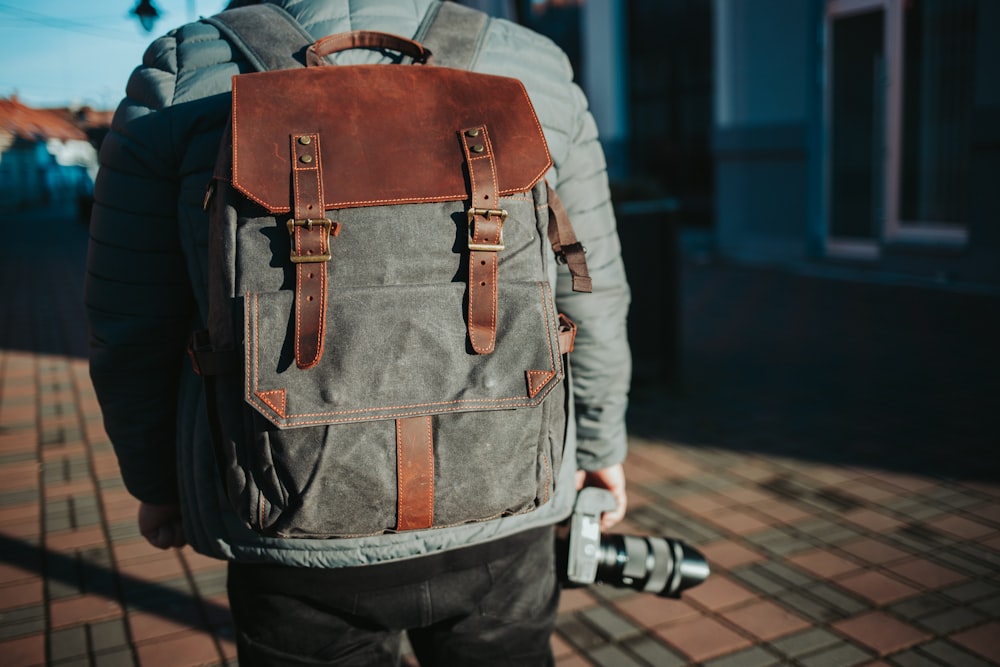 person in brown leather backpack