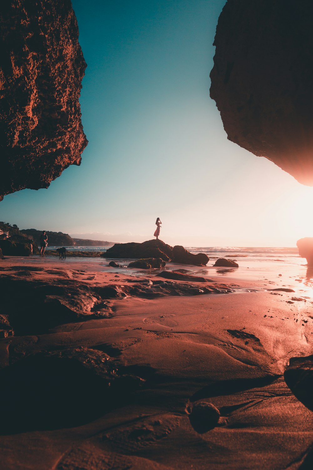 person standing on rock formation near sea during daytime