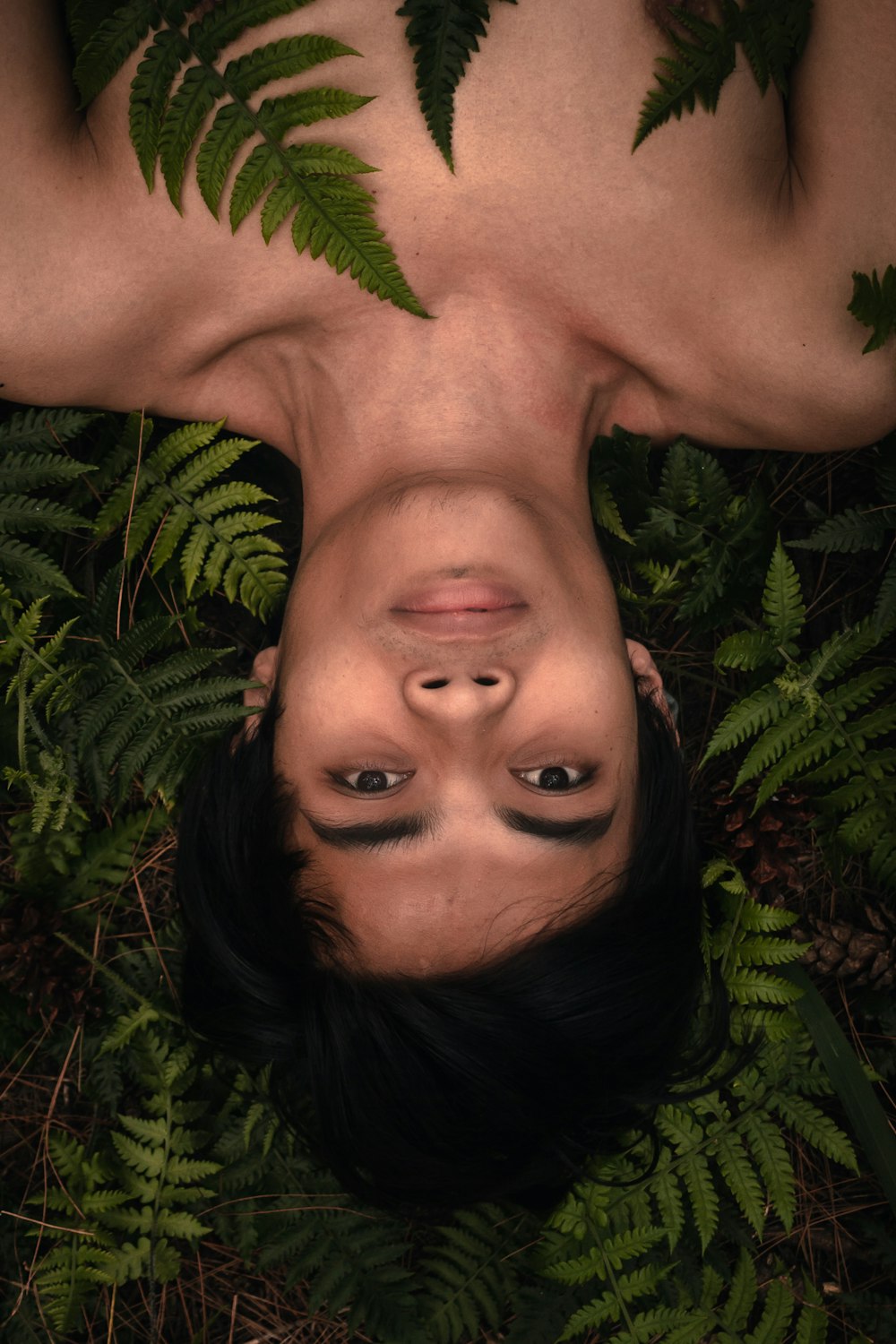 topless woman lying on green leaves