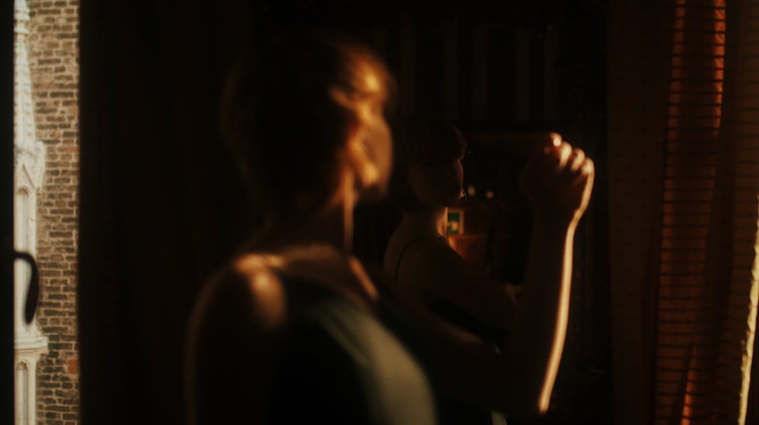 woman in white tank top holding clear drinking glass