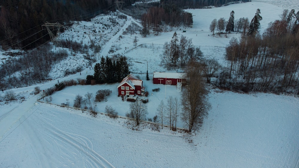 Casa roja y blanca en suelo cubierto de nieve