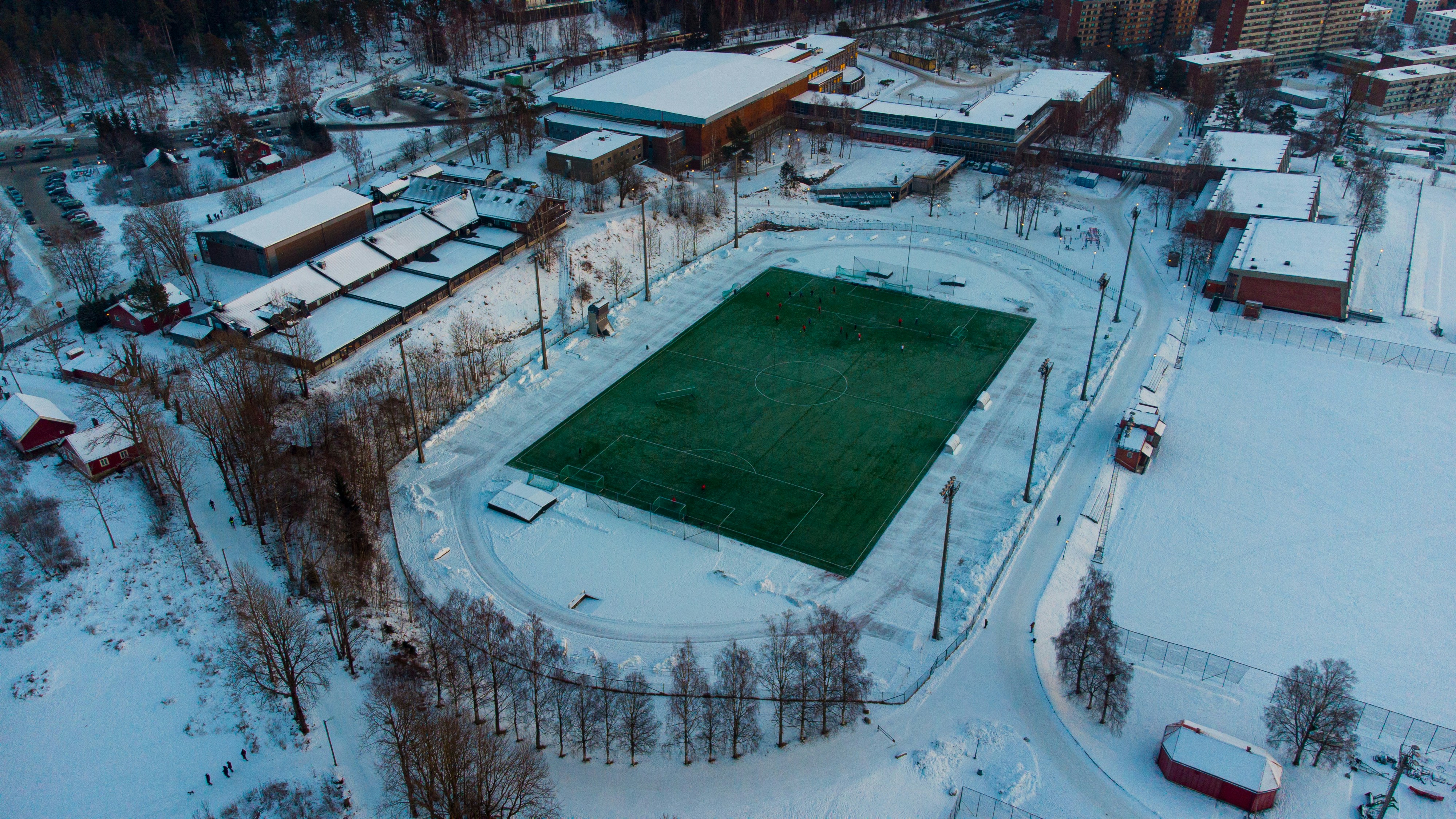 Estadio de fútbol nevado durante un partido nocturno