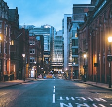 cars on road between high rise buildings during night time