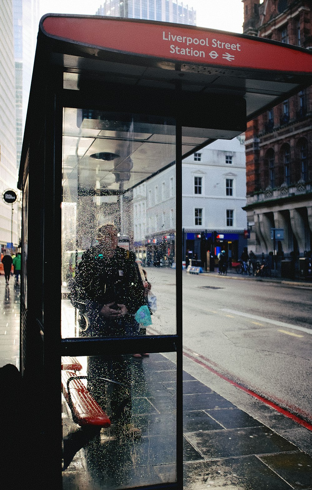 woman in black jacket sitting on chair in front of glass window