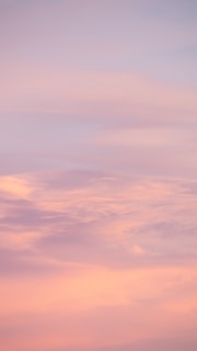 Soft lavender light filtering through delicate angel wings in a serene sky