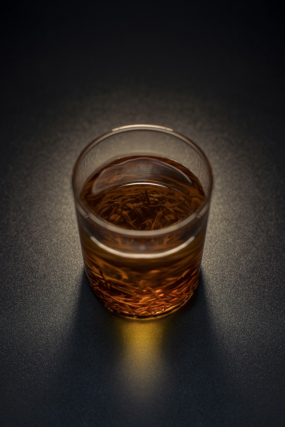Clear drinking glass with brown liquid on white paper photo – Free