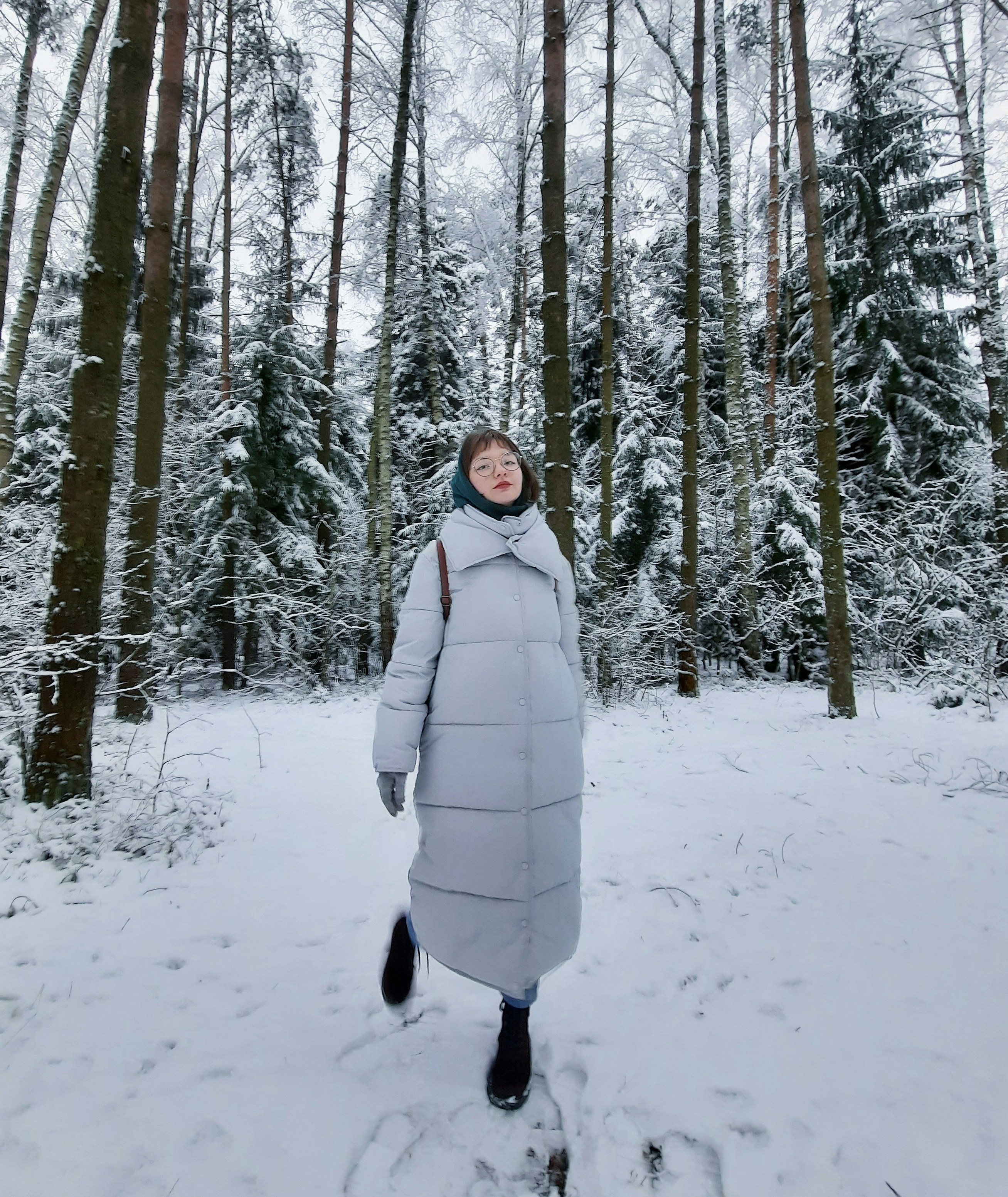 woman in white winter coat standing on snow covered ground