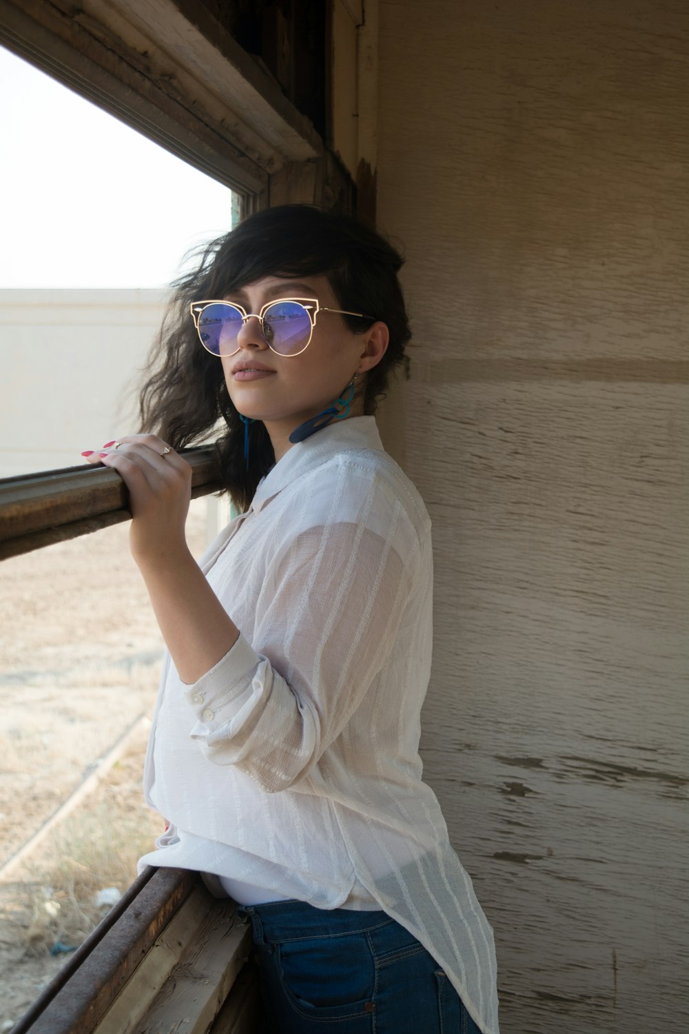 woman in white shirt wearing blue sunglasses