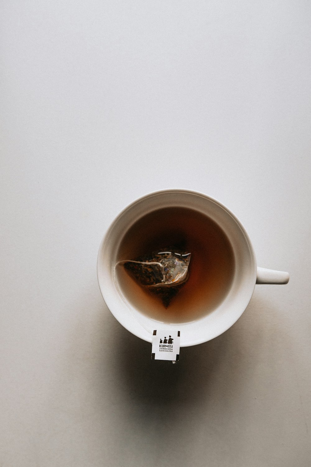 white ceramic mug with brown liquid inside