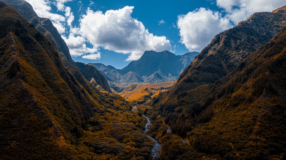 green and brown mountains under blue sky and white clouds during daytime