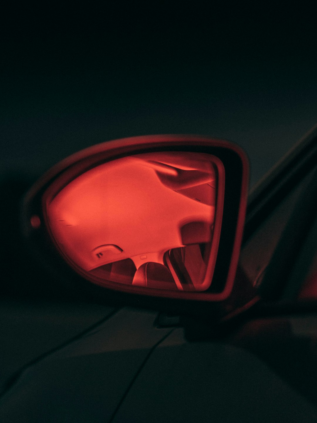 red car side mirror reflecting red light