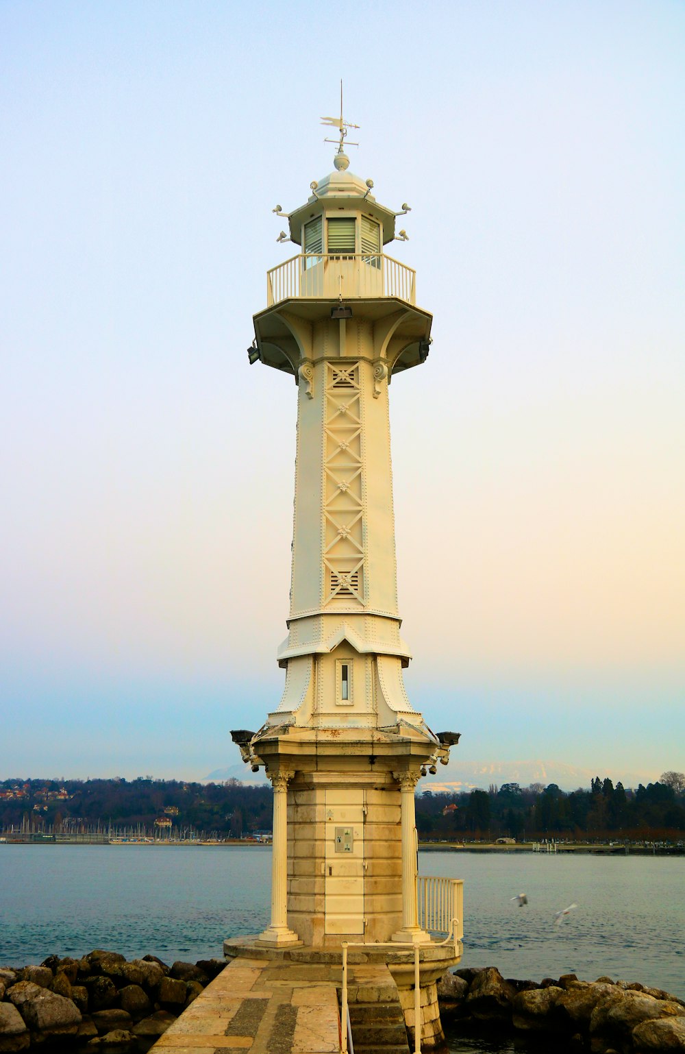 white and brown lighthouse near body of water during daytime