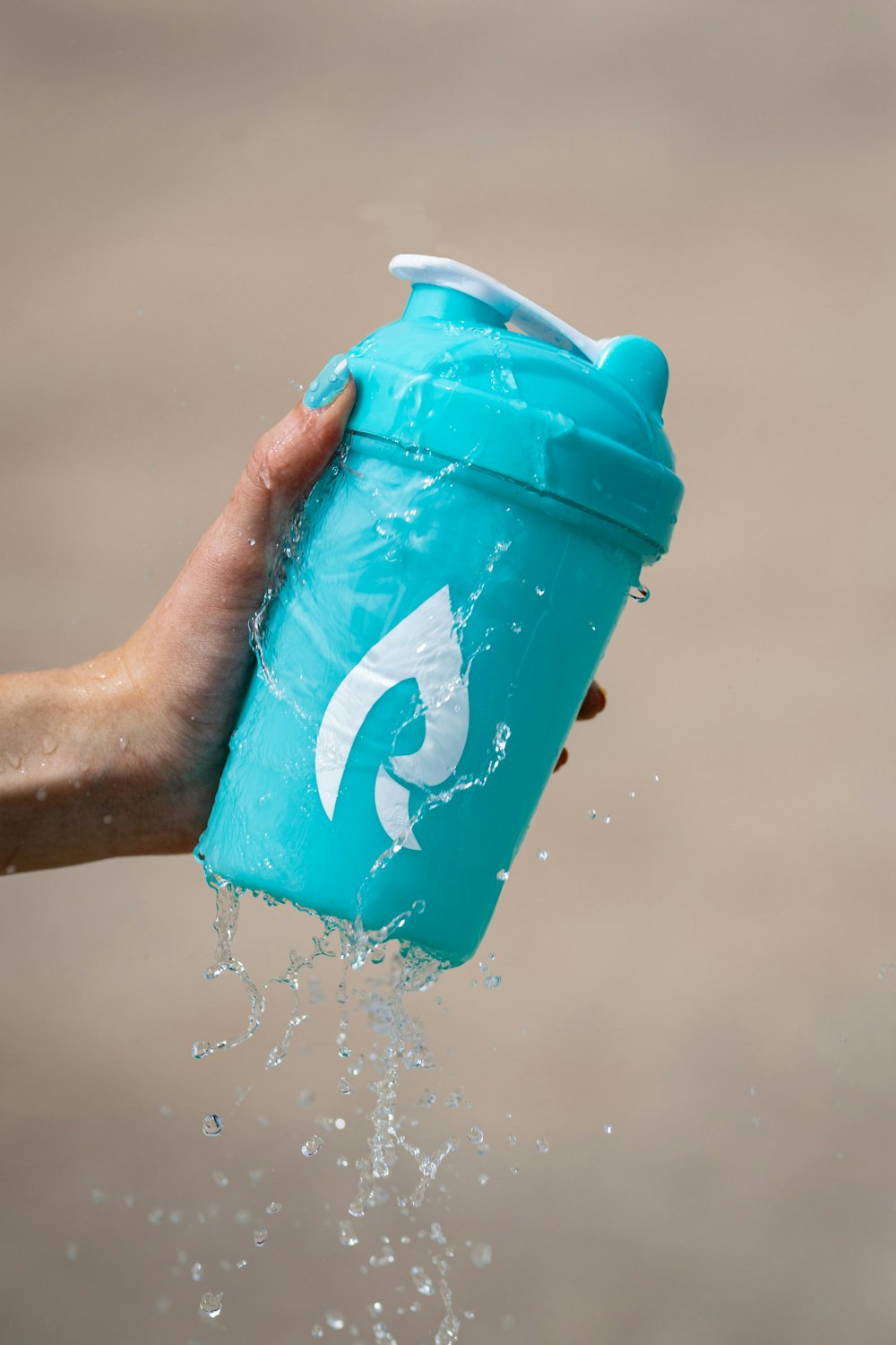 person holding blue plastic cup with water