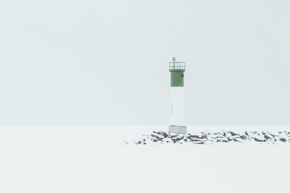 white and green lighthouse under white sky