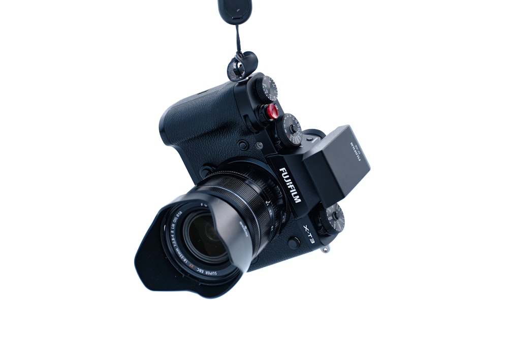 Fotocamera DSLR nera su sfondo bianco