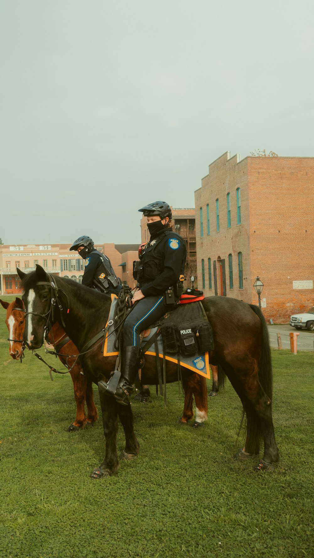 2 men riding horses on green grass field during daytime