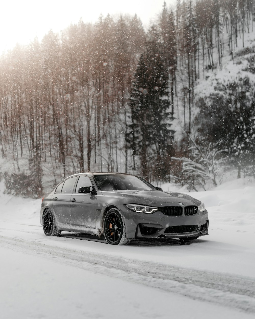 Schwarzes BMW Coupé tagsüber auf verschneiter Straße