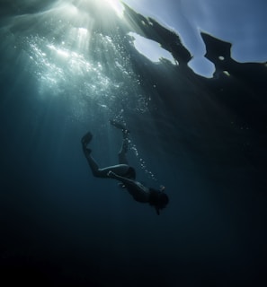 man in black shorts diving on water