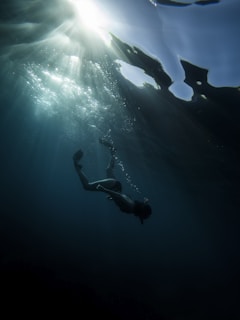 man in black shorts diving on water