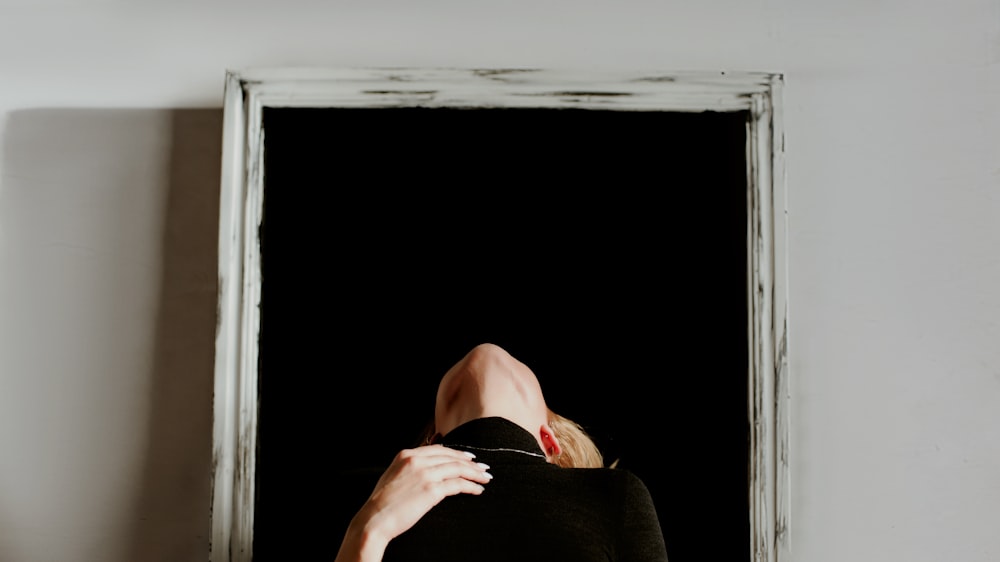 person in black shirt lying on bed