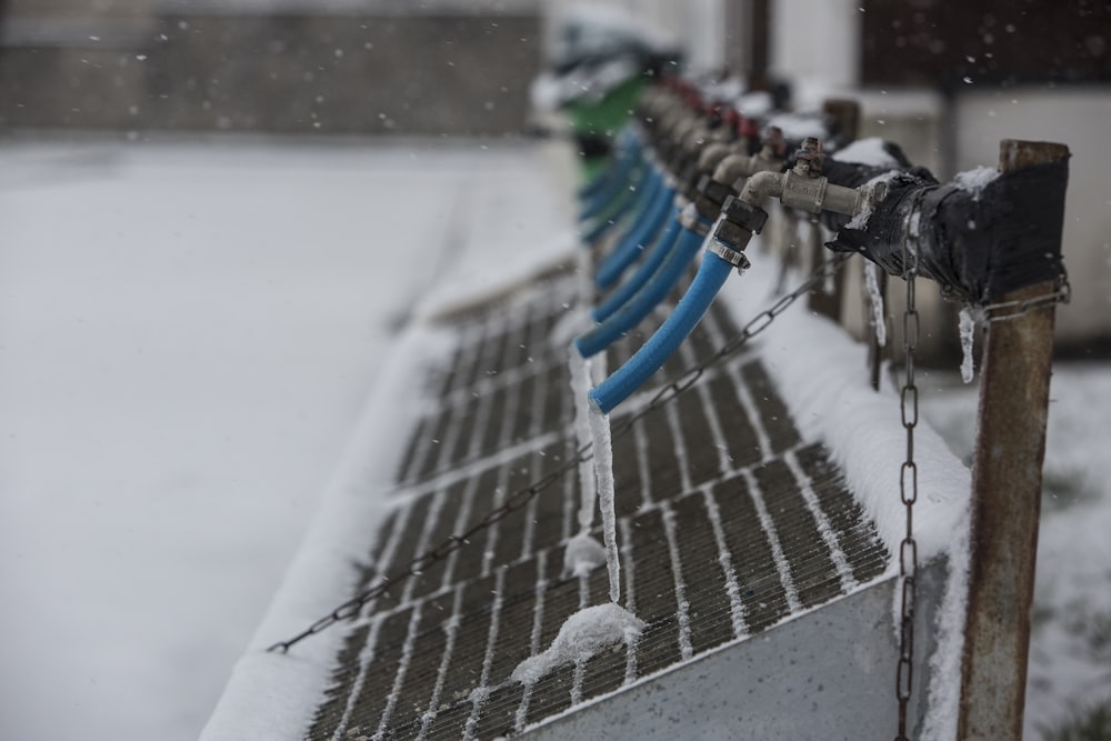 blue and black metal fence covered with snow