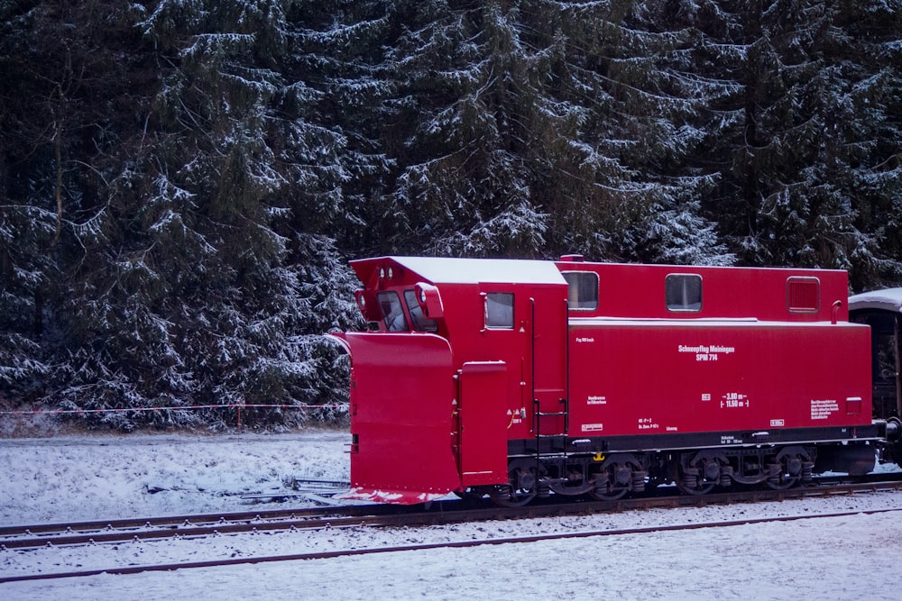 red train on rail tracks during daytime