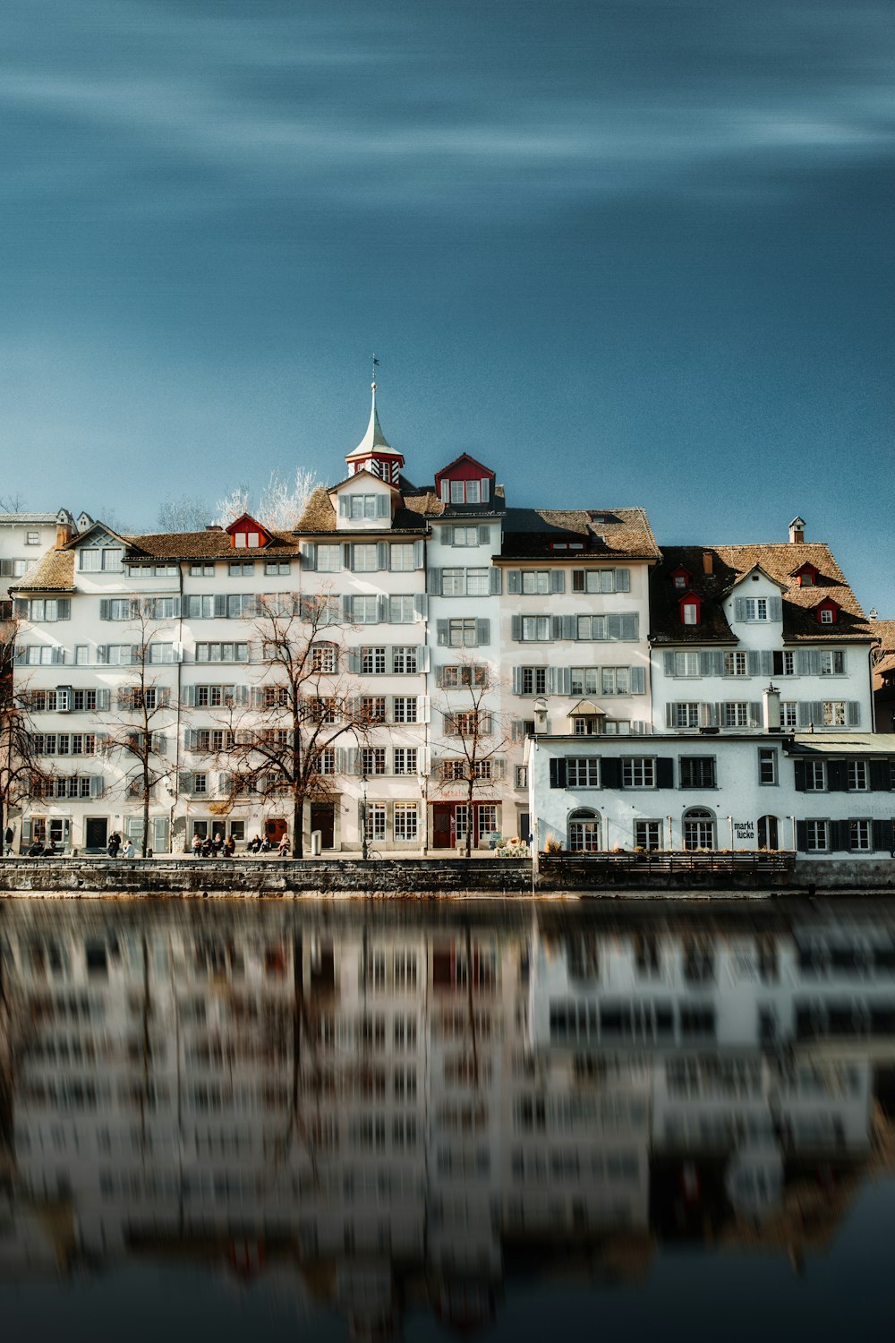 white and brown concrete building near body of water during daytime