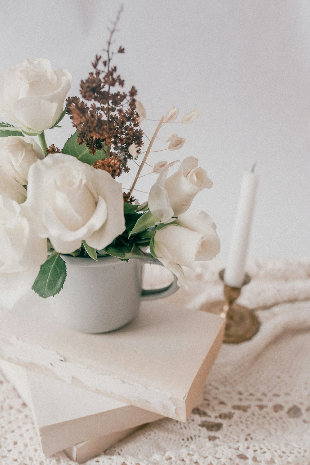 white roses in white ceramic mug