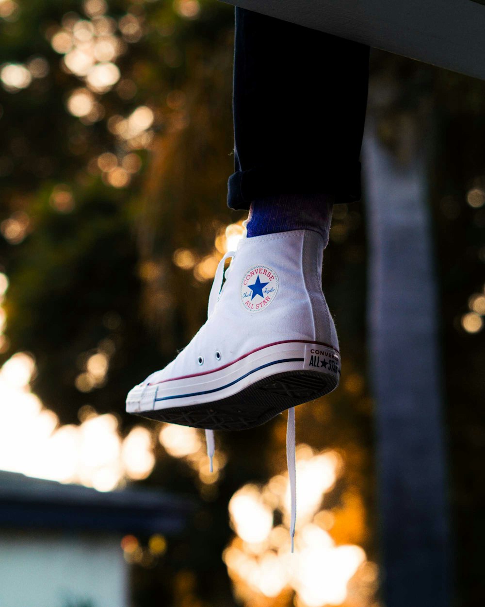 person wearing blue and white converse all star high top sneakers