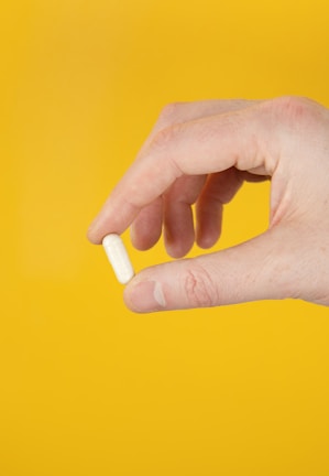 Close-up of hands preparing medicine capsules in a cleanroom.