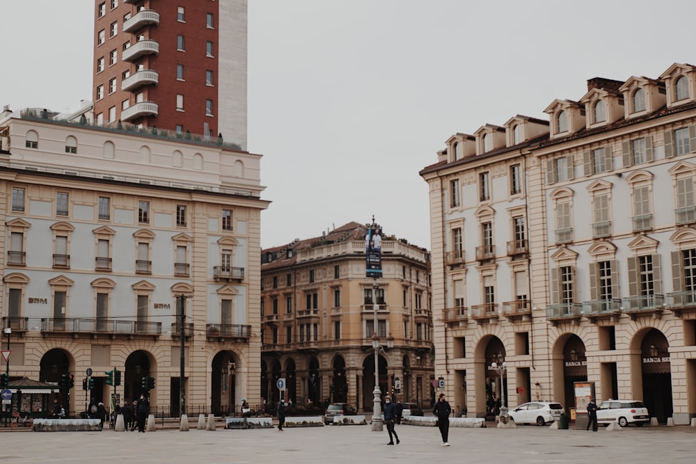 Personas caminando por la calle cerca de un edificio de hormigón marrón durante el día