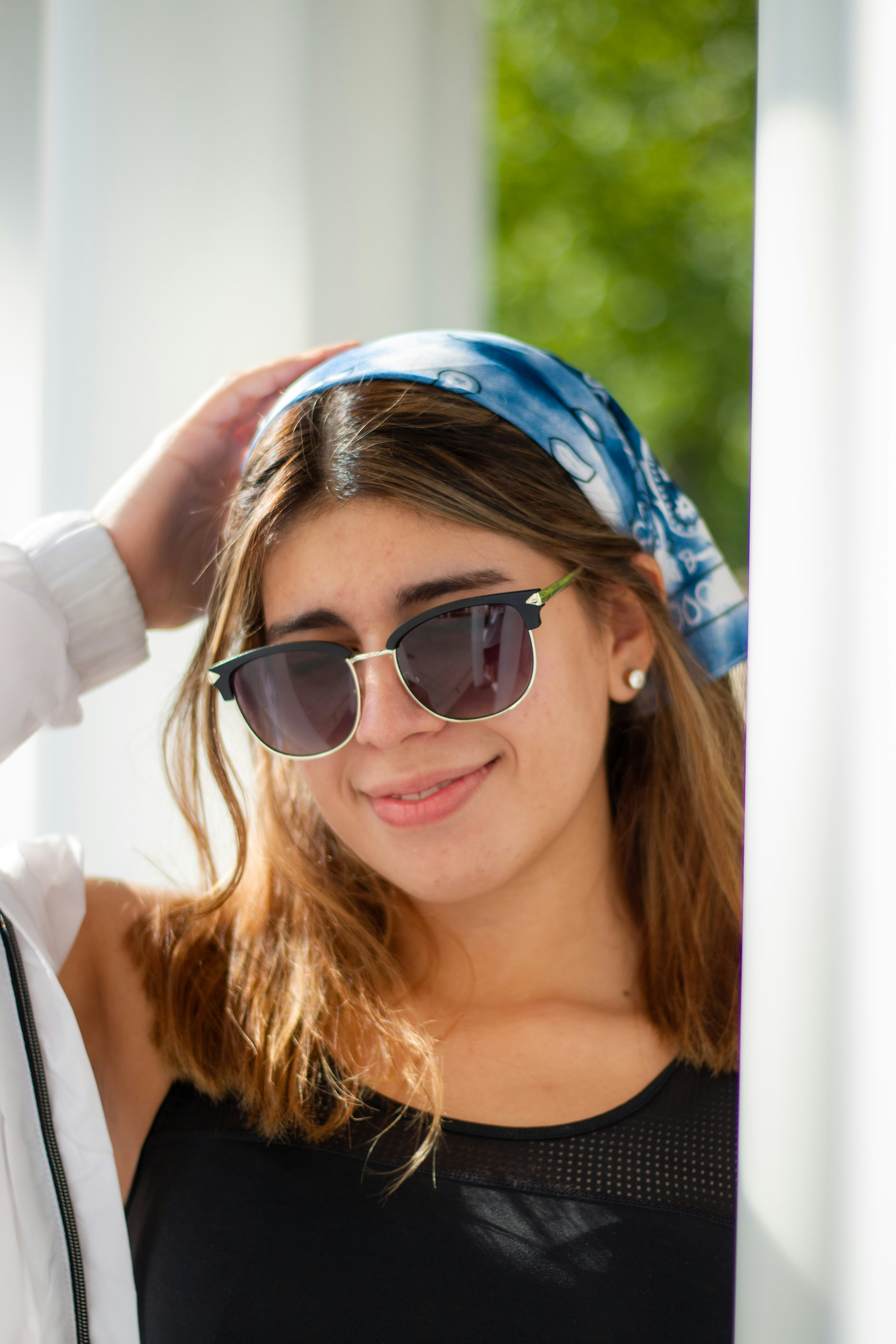 mulher na camisa branca que veste óculos de sol pretos