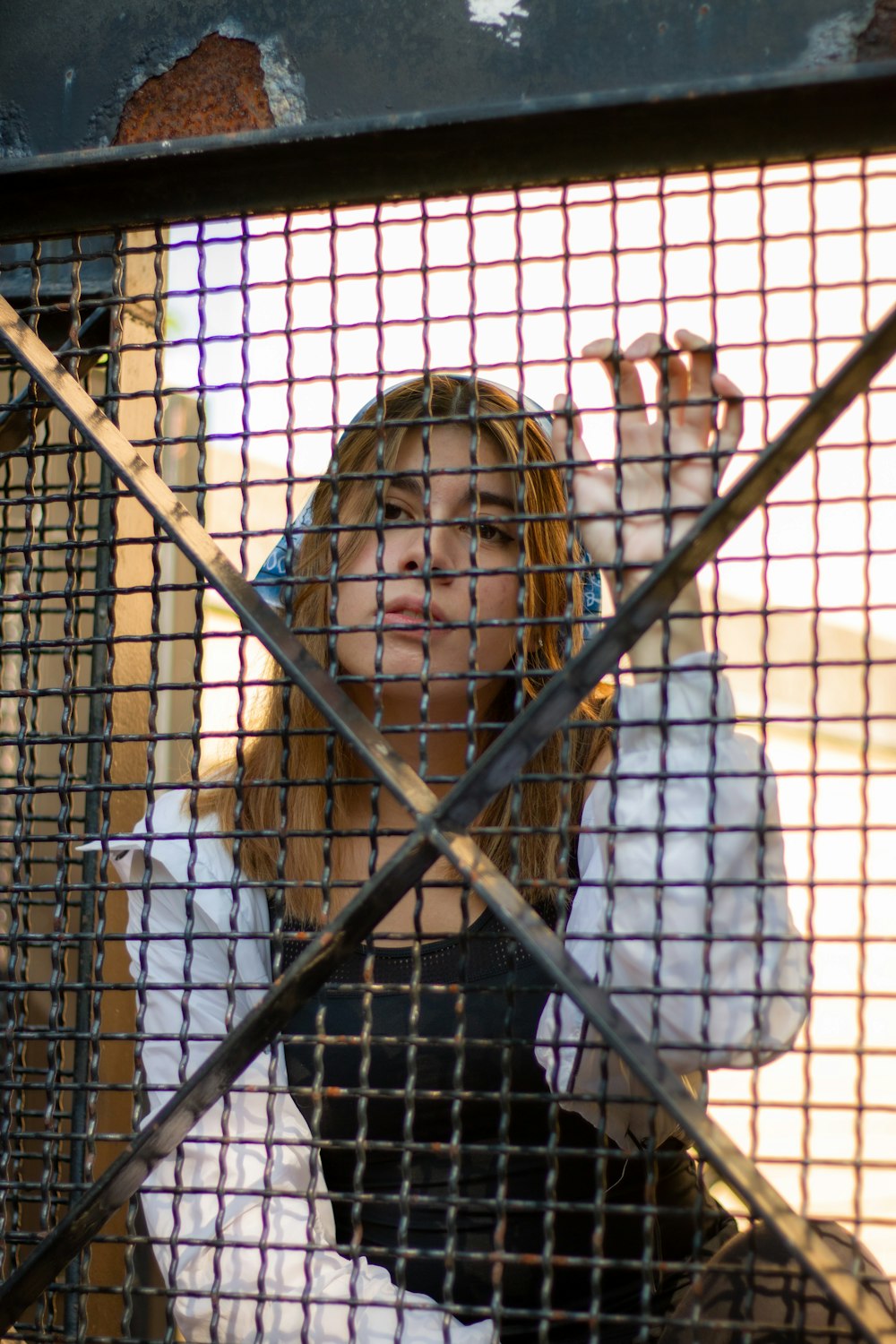 girl in white jacket standing near brown metal fence during daytime