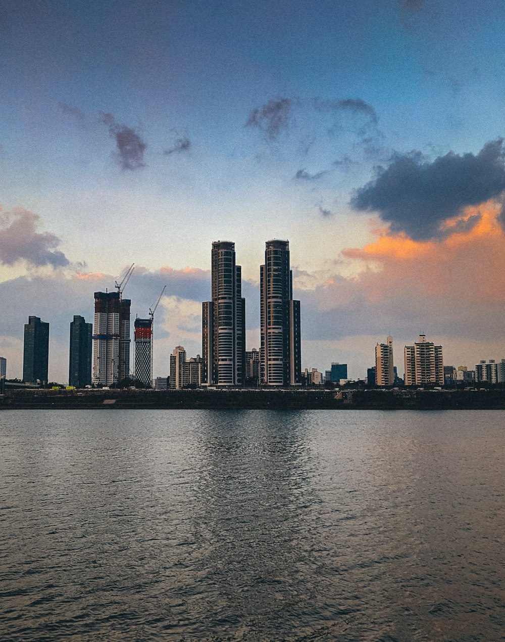 skyline della città attraverso lo specchio d'acqua durante il tramonto