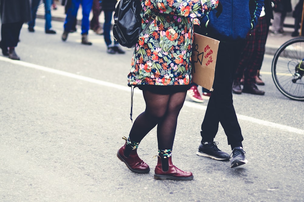 Mujer con botas de cuero negro de pie sobre suelo de hormigón gris