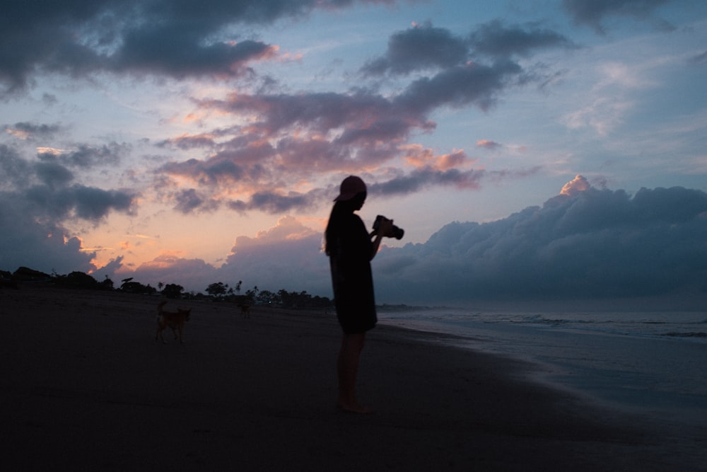 Silhouette eines Mannes, der bei Sonnenuntergang am Strand steht