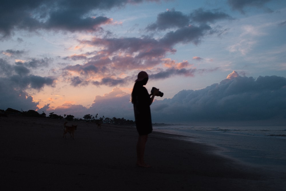 silhouette of man standing on beach during sunset