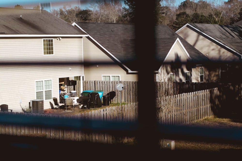 white and gray wooden house near green trees during daytime