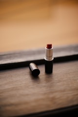 red lipstick on brown wooden table