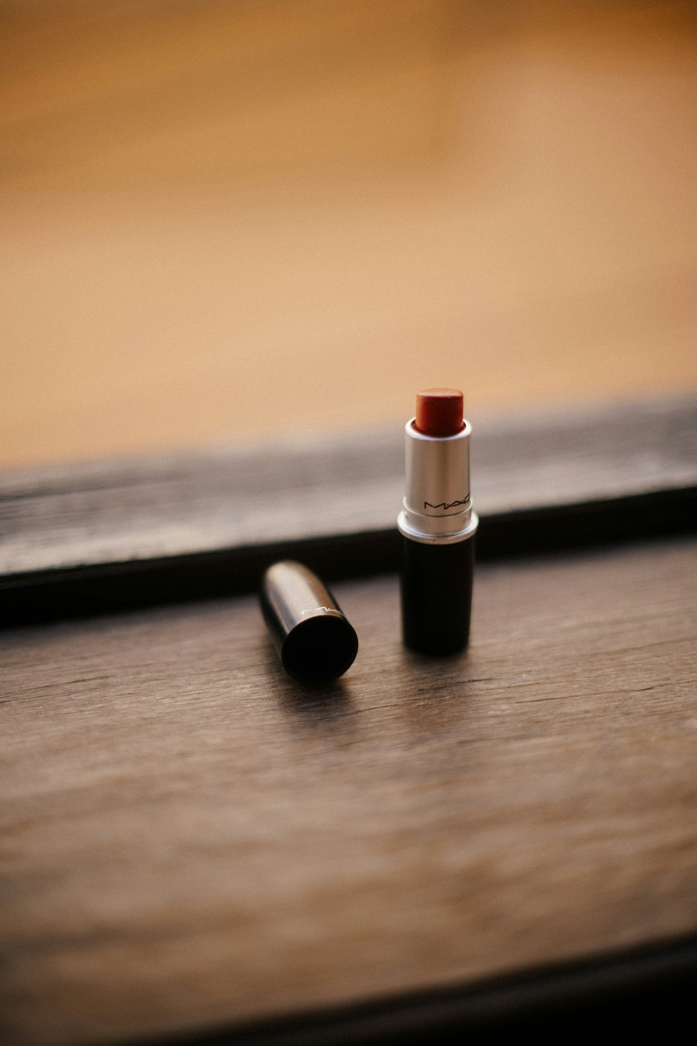 red lipstick on brown wooden table