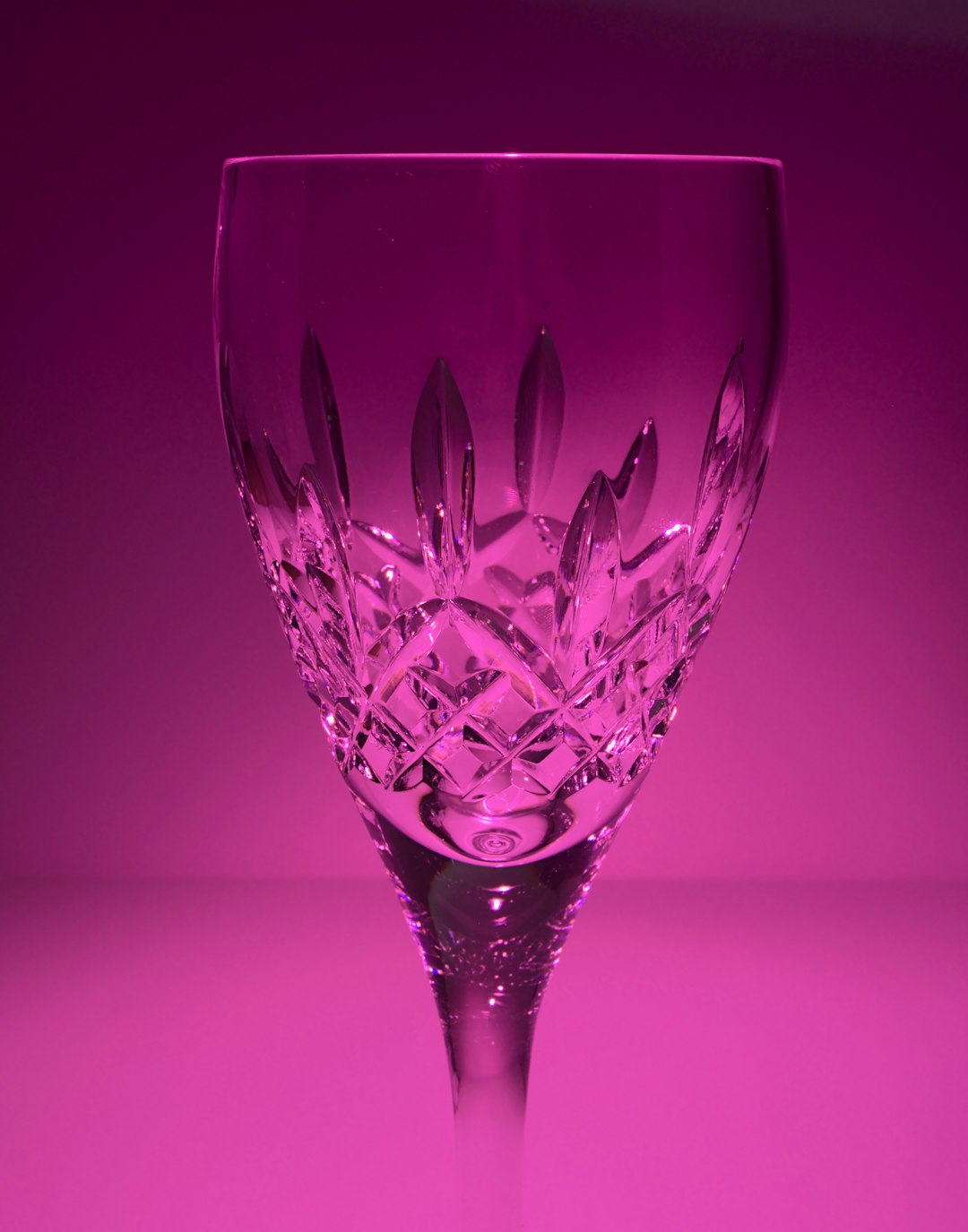 red wine glass on pink surface